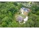 An aerial view of a home with a large driveway and expansive yard surrounded by trees at 799 Wagon Trl, Woodstock, GA 30188
