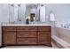 Bathroom featuring a double vanity, stone countertop, dark wood cabinets and framed mirror at 799 Wagon Trl, Woodstock, GA 30188