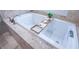 Close-up of soaking tub with jets, stone surround, and convenient wooden tray at 799 Wagon Trl, Woodstock, GA 30188