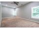 Bright, carpeted bedroom with two windows, a ceiling fan, and neutral wall color at 799 Wagon Trl, Woodstock, GA 30188