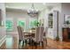 Cozy dining room with large windows, chandelier lighting, and hardwood floors at 799 Wagon Trl, Woodstock, GA 30188