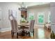 Bright dining room with picture windows, modern chandelier, and hardwood floors at 799 Wagon Trl, Woodstock, GA 30188