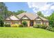 Charming brick and stone home with manicured lawn and mature trees in a desirable neighborhood at 799 Wagon Trl, Woodstock, GA 30188