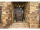 Inviting covered front entry features stone accents, a rustic wood door and professional landscaping at 799 Wagon Trl, Woodstock, GA 30188