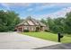 Charming home with manicured lawn, mature trees, and a long driveway at 799 Wagon Trl, Woodstock, GA 30188