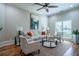 Bright living room with hardwood floors, stylish furniture, and large sunlit windows at 799 Wagon Trl, Woodstock, GA 30188