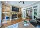 Inviting living room featuring a stone fireplace, hardwood floors, and access to the backyard at 799 Wagon Trl, Woodstock, GA 30188