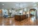 Open-concept kitchen and living area with island, stone fireplace, and hardwood floors throughout at 799 Wagon Trl, Woodstock, GA 30188
