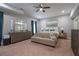 Spacious bedroom with a ceiling fan, sitting area, and dresser with decorative mirror at 799 Wagon Trl, Woodstock, GA 30188