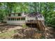Spacious backyard with deck, screened porch and staircase offers a serene outdoor living space surrounded by mature trees at 1104 Warrenhall Ne Ln, Brookhaven, GA 30319