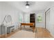 Bright bedroom featuring white trim, a ceiling fan, hardwood floors, and a writing desk by the window at 1104 Warrenhall Ne Ln, Brookhaven, GA 30319