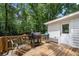 Inviting deck with grilling area and seating, perfect for outdoor relaxation and entertaining amidst a lush, wooded backdrop at 1104 Warrenhall Ne Ln, Brookhaven, GA 30319