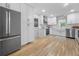 Updated kitchen features white cabinets, stainless steel appliances, and hardwood floors at 1104 Warrenhall Ne Ln, Brookhaven, GA 30319