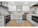 Bright kitchen features white cabinets, modern appliances, farmhouse sink, and hardwood floors at 1104 Warrenhall Ne Ln, Brookhaven, GA 30319