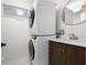 Modern laundry area with stacked washer and dryer unit and a vanity with a decorative light fixture at 1104 Warrenhall Ne Ln, Brookhaven, GA 30319