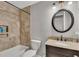 Bathroom featuring a built in shower shelf, a marble counter, and a large round mirror at 3271 Sutcliffe Nw Rdg, Marietta, GA 30064