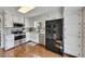 Bright kitchen features white cabinets, granite countertops, stainless steel appliances, and wood flooring at 3271 Sutcliffe Nw Rdg, Marietta, GA 30064