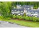 Aerial view of new townhome construction featuring manicured lawns and a tree lined street at 429 Stovall Pl, Woodstock, GA 30188