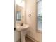 Bright half bath with a pedestal sink, bronze fixtures and a window at 429 Stovall Pl, Woodstock, GA 30188
