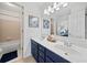 Bright bathroom with dual sinks, blue vanity, framed art, and tile shower at 514 Augusta Dr, Canton, GA 30115