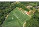 Aerial view of a sports field and surrounding woods with small buildings and paths at 6004 Turfway Park Ct, Sugar Hill, GA 30518