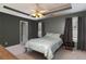 Spacious bedroom with a tray ceiling, neutral carpet, and large windows for plenty of natural light at 6004 Turfway Park Ct, Sugar Hill, GA 30518