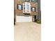 Close-up view of the townhome with a white garage door, brick facade, and a bay window at 6004 Turfway Park Ct, Sugar Hill, GA 30518
