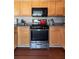 The cozy kitchen has wood cabinets, stainless steel appliances, and hardwood floors for a warm, inviting atmosphere at 6004 Turfway Park Ct, Sugar Hill, GA 30518