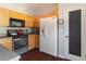Well-lit kitchen features wood cabinets, black appliances, and access to a pantry for organized storage at 6004 Turfway Park Ct, Sugar Hill, GA 30518