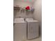 Functional laundry room with a front-load washer and dryer, plus a wire shelf for storage at 6004 Turfway Park Ct, Sugar Hill, GA 30518