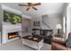 Living room features a fireplace, neutral paint, plush furnishings and a ceiling fan at 6004 Turfway Park Ct, Sugar Hill, GA 30518