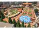Overhead view of a town center featuring an amphitheater, fountain, green spaces, and surrounding buildings at 6004 Turfway Park Ct, Sugar Hill, GA 30518