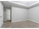Bedroom showcasing neutral walls, carpet, a tray ceiling, and an open doorway at 7190 Cavender Sw Dr, Atlanta, GA 30331