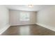 Bright bedroom features wood flooring, a large window, and a flush mount ceiling light at 7190 Cavender Sw Dr, Atlanta, GA 30331