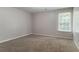 Bright bedroom features plush carpeting, a large window, and neutral paint, creating a calming space at 7190 Cavender Sw Dr, Atlanta, GA 30331