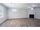 Open living room features luxury vinyl plank flooring, modern ceiling fan, fireplace, and natural light at 7190 Cavender Sw Dr, Atlanta, GA 30331