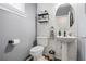 Charming powder room features gray walls, shiplap accent wall, and a pedestal sink at 130 Nacoochee Way, Canton, GA 30114