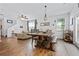 Open-concept dining area featuring a large wood table, hardwood floors, and view of living room at 130 Nacoochee Way, Canton, GA 30114