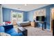 Blue bedroom with carpeted floors and a sofa, bed, and desk with a world map above it at 2700 Still Farms Ct, Lawrenceville, GA 30043