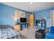 Blue bedroom with carpet, a tv, desk, and seating. There is an ensuite bathroom in the corner at 2700 Still Farms Ct, Lawrenceville, GA 30043