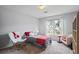 Neutral bedroom with gray walls and carpet and an armchair and large window with a backyard view at 2700 Still Farms Ct, Lawrenceville, GA 30043