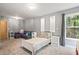 Neutral bedroom with gray walls and carpet, a bed, seating, and backyard view from the window at 2700 Still Farms Ct, Lawrenceville, GA 30043