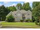 Charming brick home featuring manicured lawn and mature trees, enhancing its curb appeal at 2700 Still Farms Ct, Lawrenceville, GA 30043