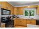 Functional kitchen features appliances, wood cabinetry, and a view of the trees outside the window at 2700 Still Farms Ct, Lawrenceville, GA 30043