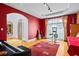 Vibrant room with red walls, hardwood floors, leading to a door with a view of an office at 2700 Still Farms Ct, Lawrenceville, GA 30043