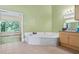 Main bathroom featuring a large soaking tub and an adjacent window offering natural light at 2700 Still Farms Ct, Lawrenceville, GA 30043