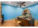 Office space featuring blue walls, wood floors, large desk, and ceiling fan at 2700 Still Farms Ct, Lawrenceville, GA 30043
