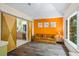 Relaxing sitting room with a cozy sofa, bright orange wall, and sliding barn doors at 2700 Still Farms Ct, Lawrenceville, GA 30043