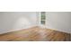An empty bedroom featuring wood-look flooring, a window, and fresh white paint at 5157 Roswell Rd # 1, Atlanta, GA 30342