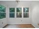 Bright dining room with hardwood floors and three windows overlooking the green trees outside at 5157 Roswell Rd # 1, Atlanta, GA 30342